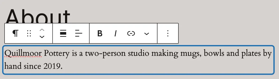 The About page in the editor: its first paragraph clicked and outlined, with the small toolbar above it